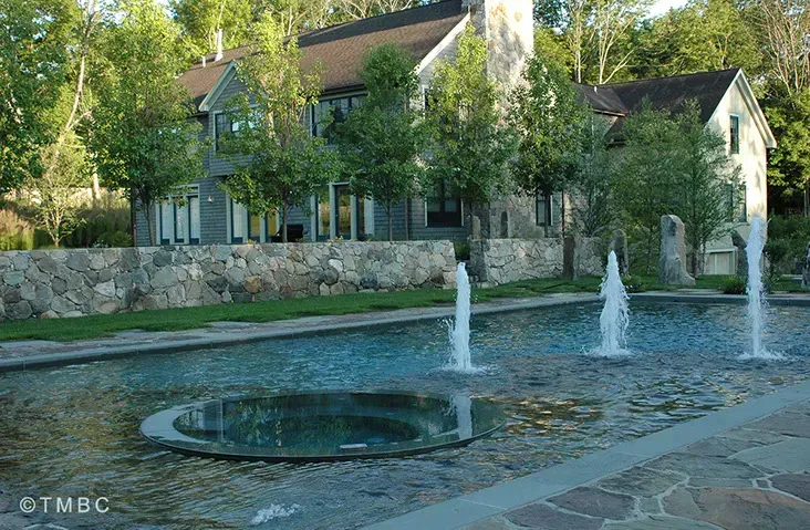 Beach entry pool design with stonework, spa, and water feature details image 2