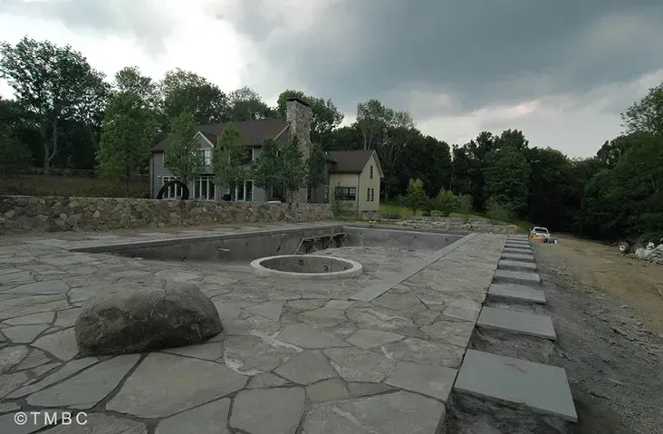 Beach entry pool design with stonework, spa, and water feature details image 7